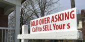 A house for sale sign that says "sold over asking."