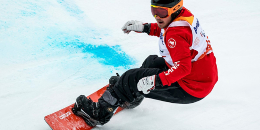 A close shot of Tyler Turner taking a hard turn on his snowboard.