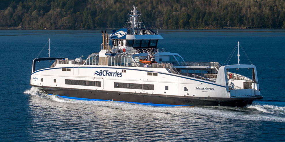 A shot of the Island Aurora ferry with a tree-covered island in the background.