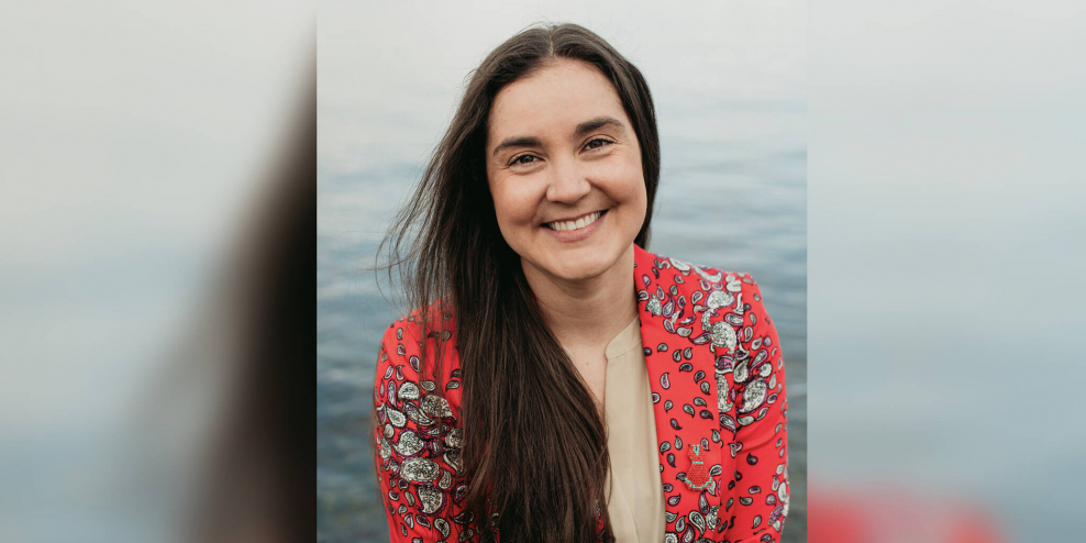 Tanille Johnston smiles in front of an ocean backdrop.